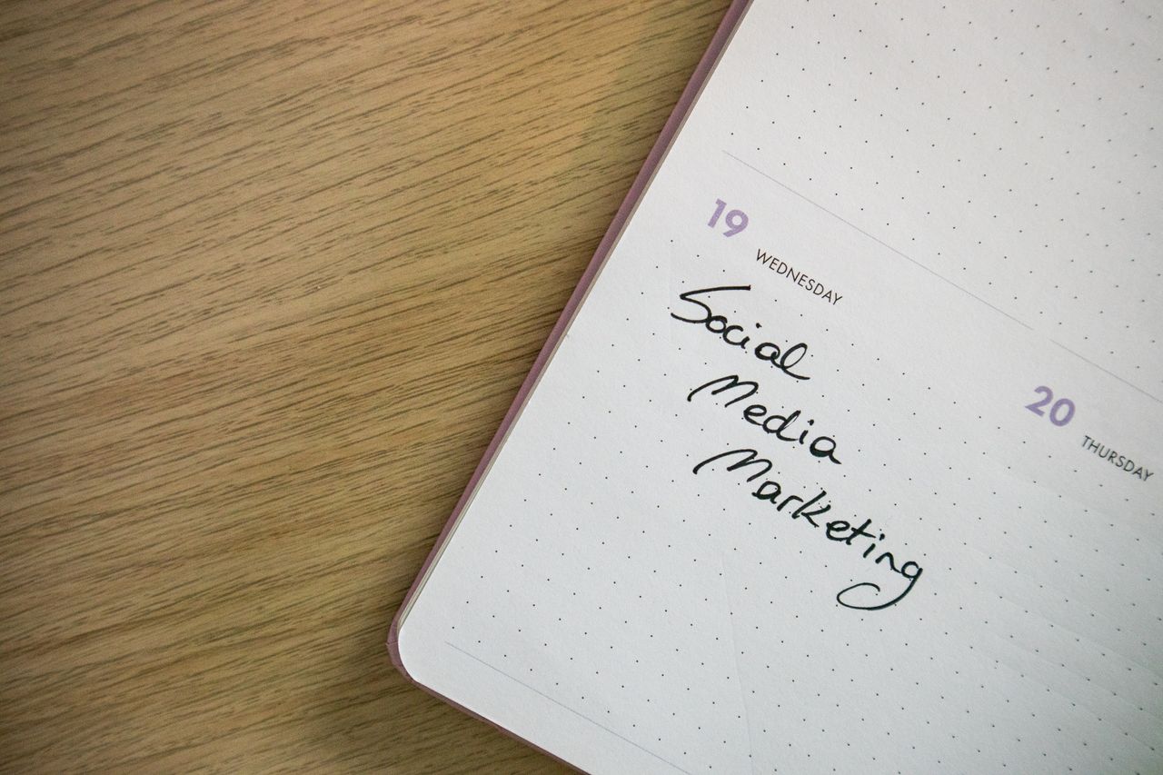 Close-up shot of a notebook page bearing the handwritten words Social Media Marketing.
